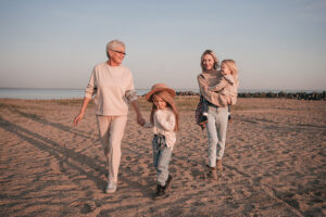 Mature woman walking on the beach with adult daughter and granddaughters